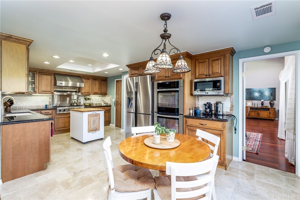 18261 Hiawatha Street Northridge, CA 91326 - Photo 15 of 35 a kitchen with stainless steel appliances kitchen island granite countertop a sink and cabinets