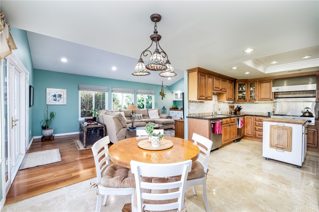 18261 Hiawatha Street Northridge, CA 91326 - Photo 19 of 35 a view of a dining room and livingroom with furniture wooden floor a rug a fireplace and a chandelier
