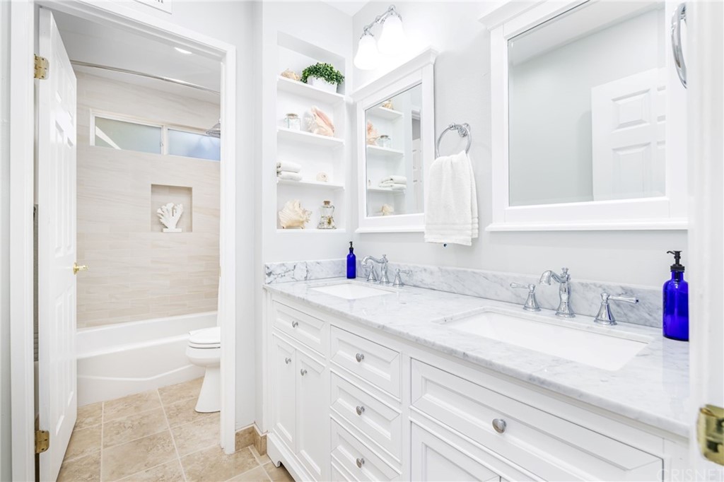 18261 Hiawatha Street Northridge, CA 91326 - Photo 23 of 35 a bathroom with a granite countertop sink a toilet and a bathtub