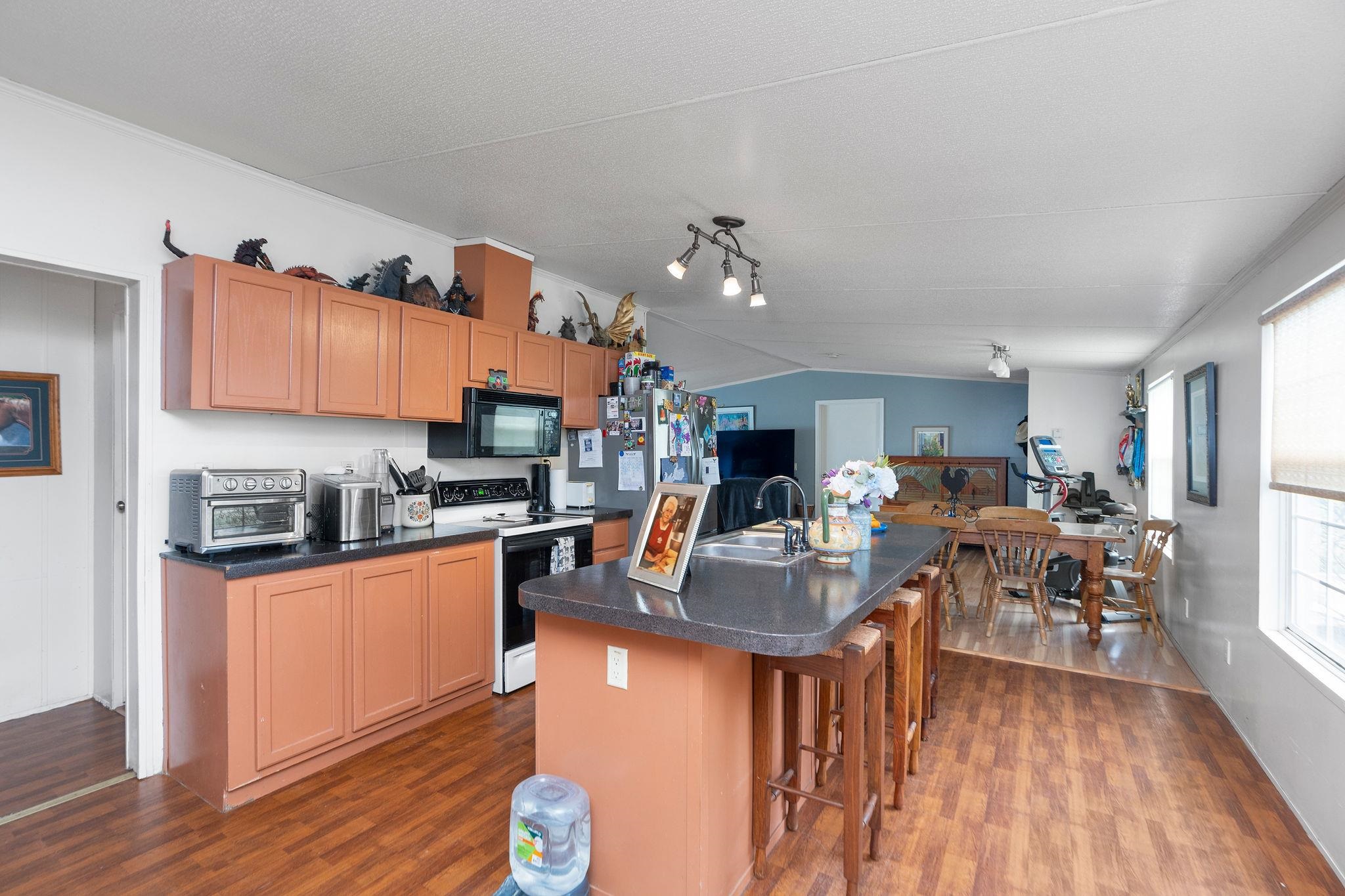 309 Old B&O Road Raphine, VA 24472 - Photo 34 of 75 a kitchen with stainless steel appliances granite countertop a refrigerator a stove top oven a dining table and chairs with wooden floor