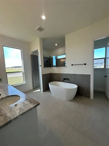 a spacious bathroom with a granite countertop sink and a mirror