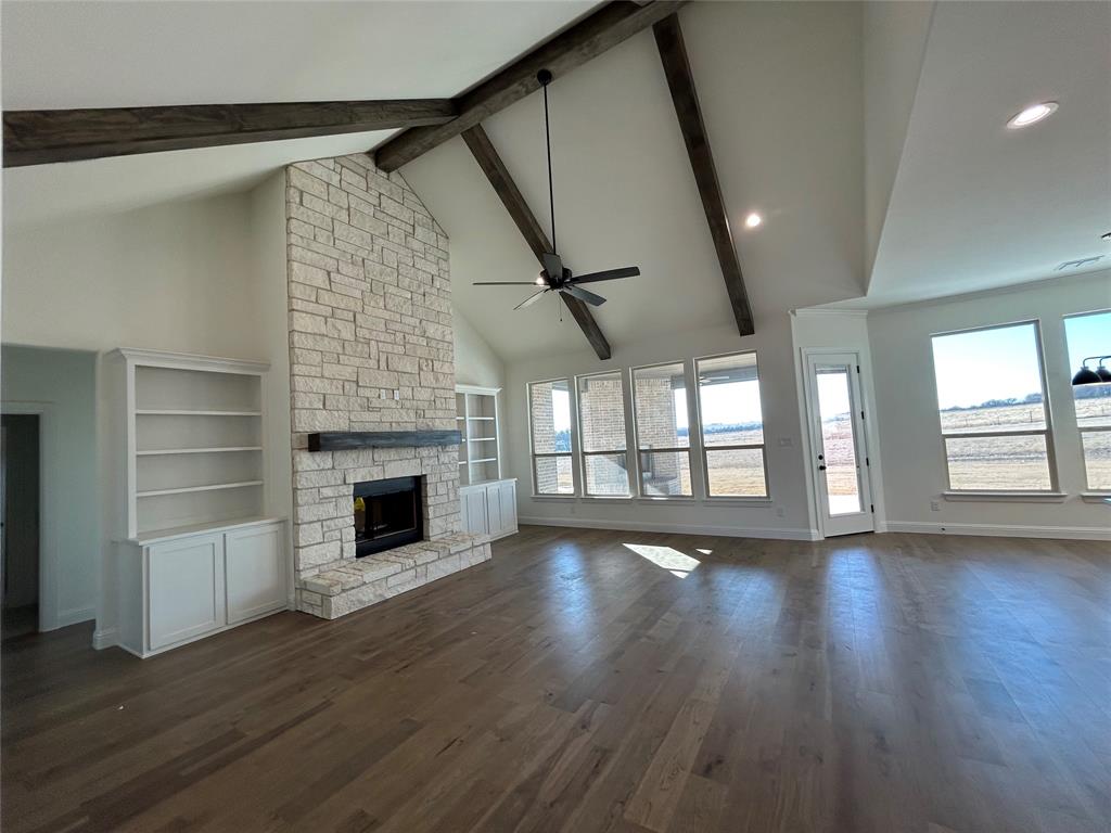 116 Blackstar Lane Decatur, TX 76234 - Photo 8 of 32 an empty room with wooden floor fireplace and windows