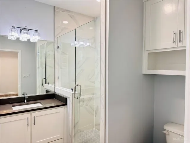 a bathroom with a granite countertop sink a mirror and a shower