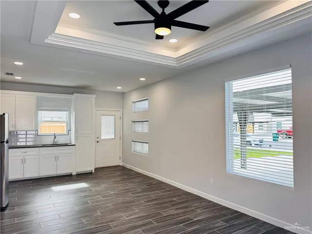a view of a kitchen with wooden floor and a window