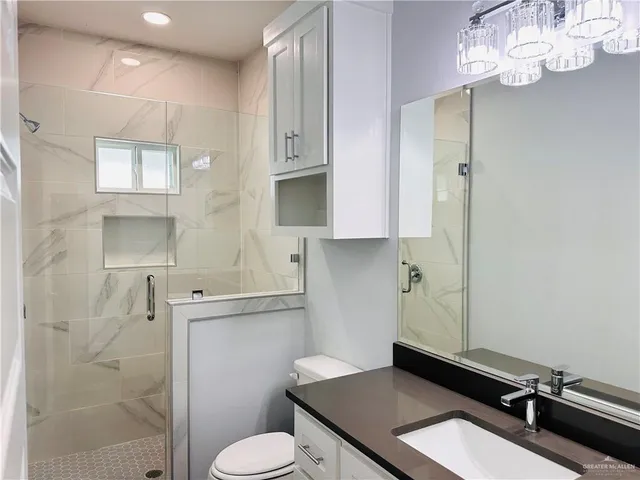 a bathroom with a sink a toilet and shower