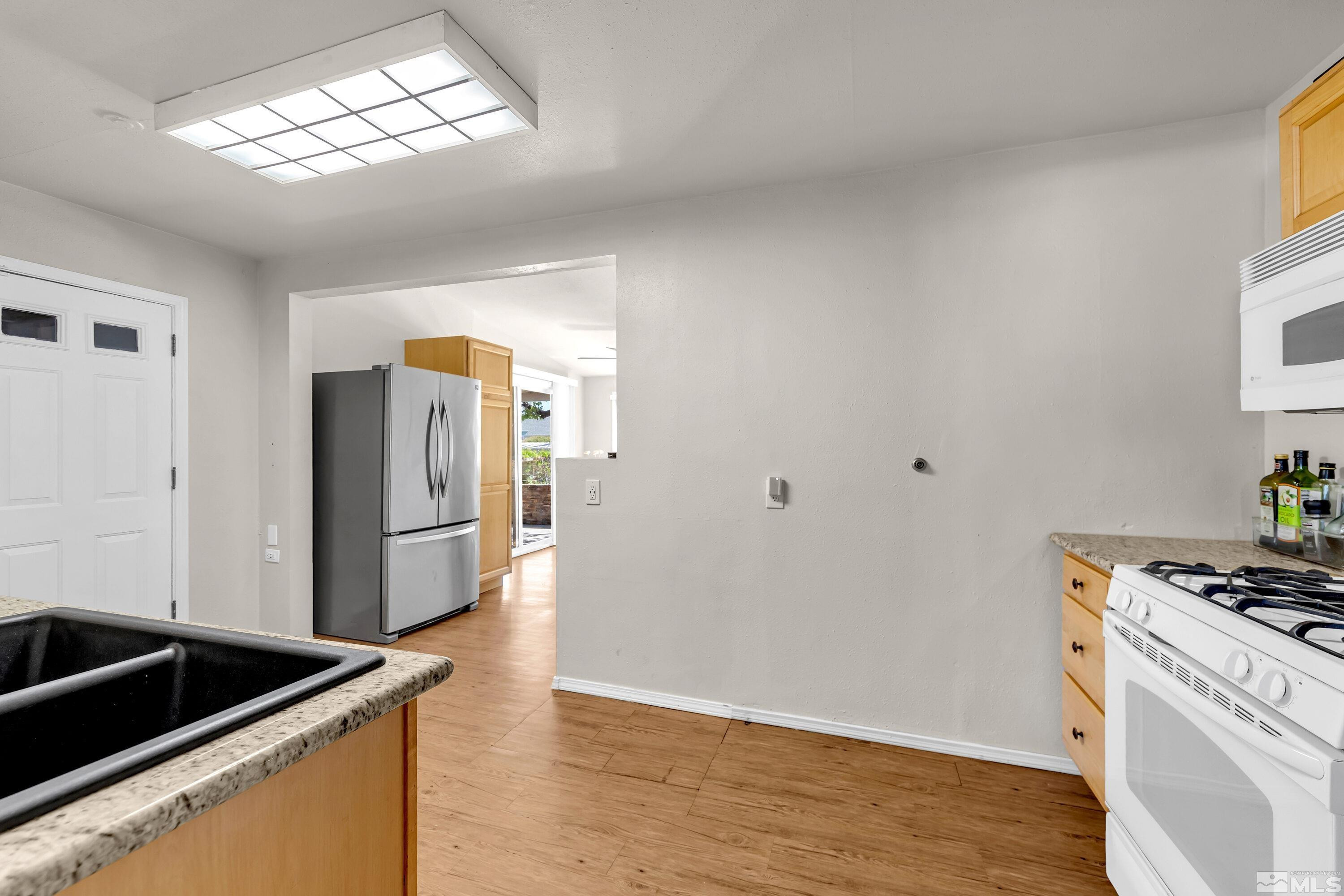 1615 Keystone Avenue Reno, NV 89503 - Photo 6 of 40 a kitchen with granite countertop a refrigerator and a stove top oven