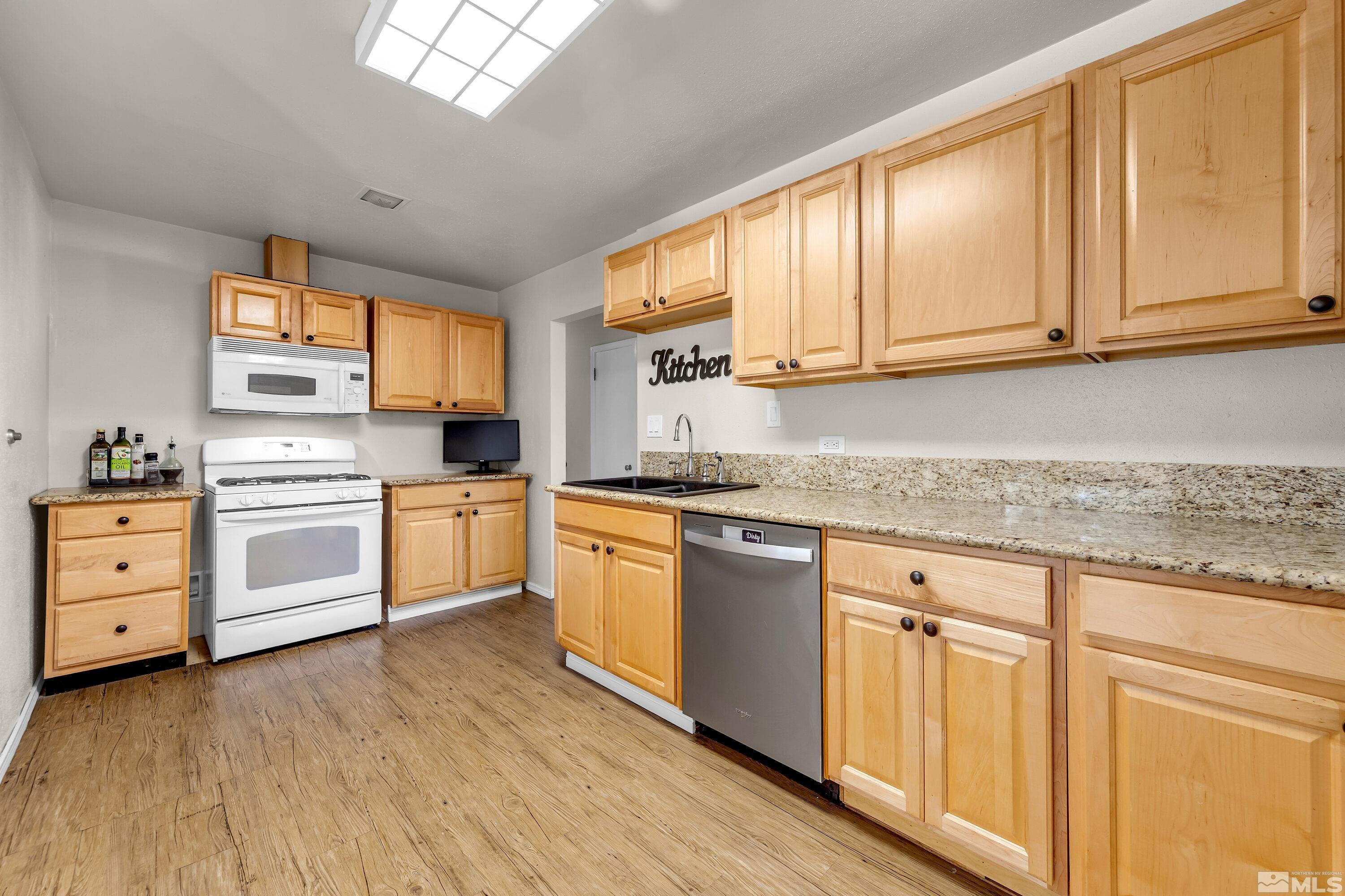 1615 Keystone Avenue Reno, NV 89503 - Photo 8 of 40 a kitchen with white cabinets and white appliances