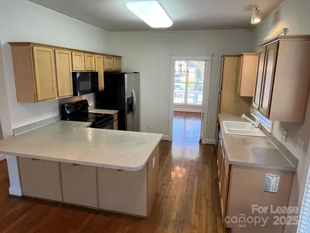 a kitchen with granite countertop a refrigerator stove and sink
