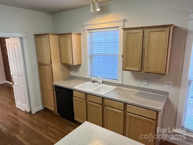 a kitchen with a refrigerator a stove top oven a sink and a window