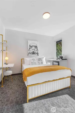 a bedroom with a bed and painting on the wall