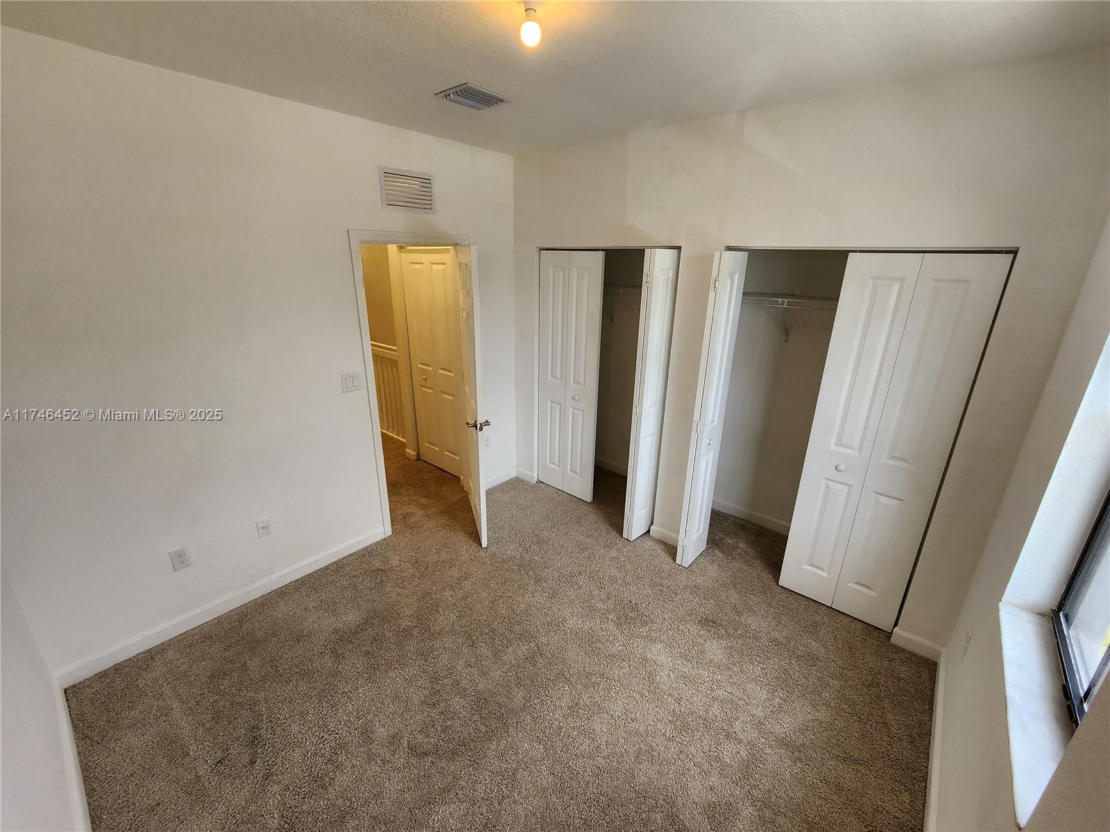 18232 Southwest 148th Road, Unit 18232 Miami, FL 33187 - Photo 21 of 44 an empty room with closet and mirror