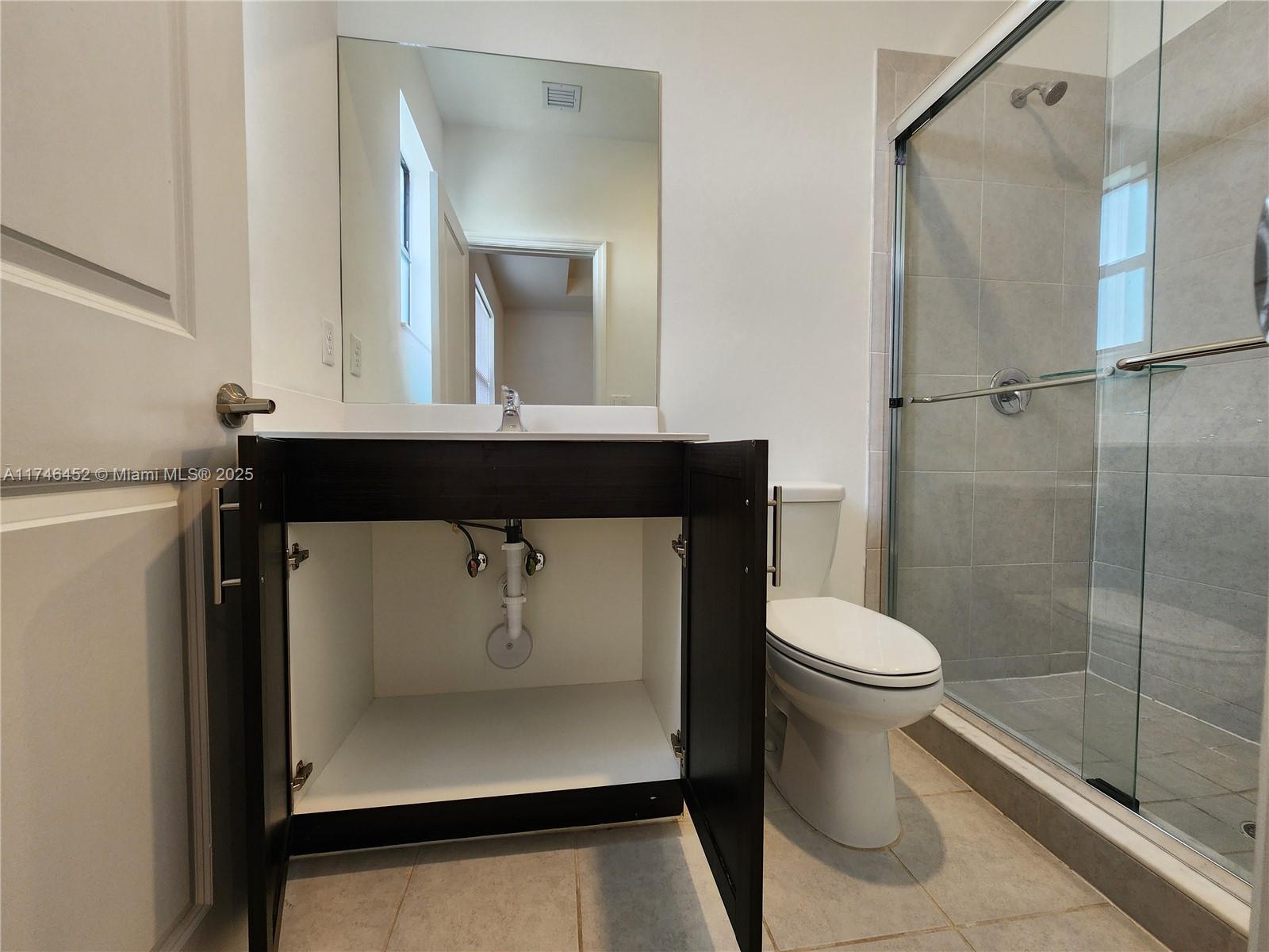 18232 Southwest 148th Road, Unit 18232 Miami, FL 33187 - Photo 29 of 44 a bathroom with a sink a toilet and shower