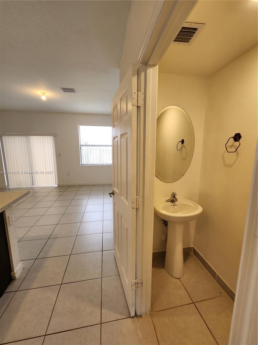 18232 Southwest 148th Road, Unit 18232 Miami, FL 33187 - Photo 31 of 44 a bathroom with a sink a toilet and mirror