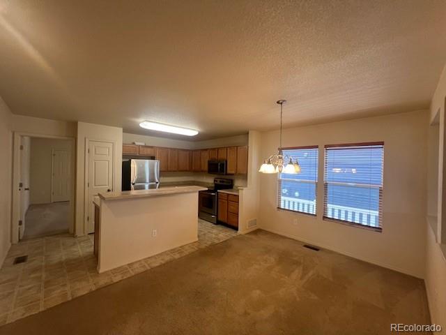 5752 Gallantry Lane Colorado Springs, CO 80923 - Photo 8 of 35 a view of a kitchen with kitchen island a sink wooden floor and a refrigerator