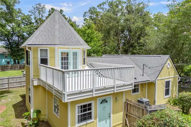 a view of a house with pool and wooden fence
