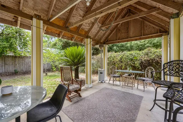 a view of a porch with furniture and a yard