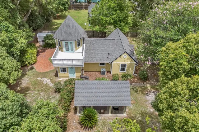 a aerial view of a house with a yard and large tree