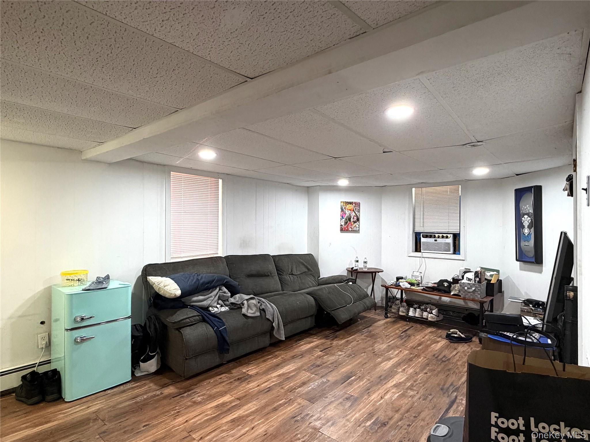 149 Fort Salonga Road Northport, NY 11768 - Photo 13 of 23 Finished room in basement featuring flooring, white paneled walls, and a dropped ceiling with recessed lighting
