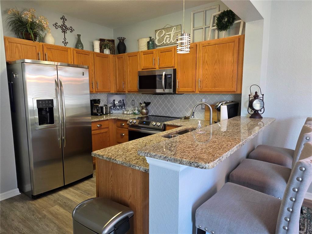 13185 Southeast 93rd Terrace Road Summerfield, FL 34491 - Photo 11 of 48 a kitchen with stainless steel appliances granite countertop a sink refrigerator and microwave