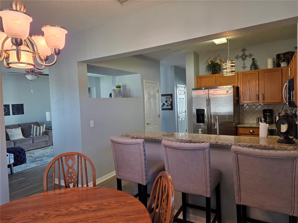 13185 Southeast 93rd Terrace Road Summerfield, FL 34491 - Photo 12 of 48 a room with a table chairs and a kitchen