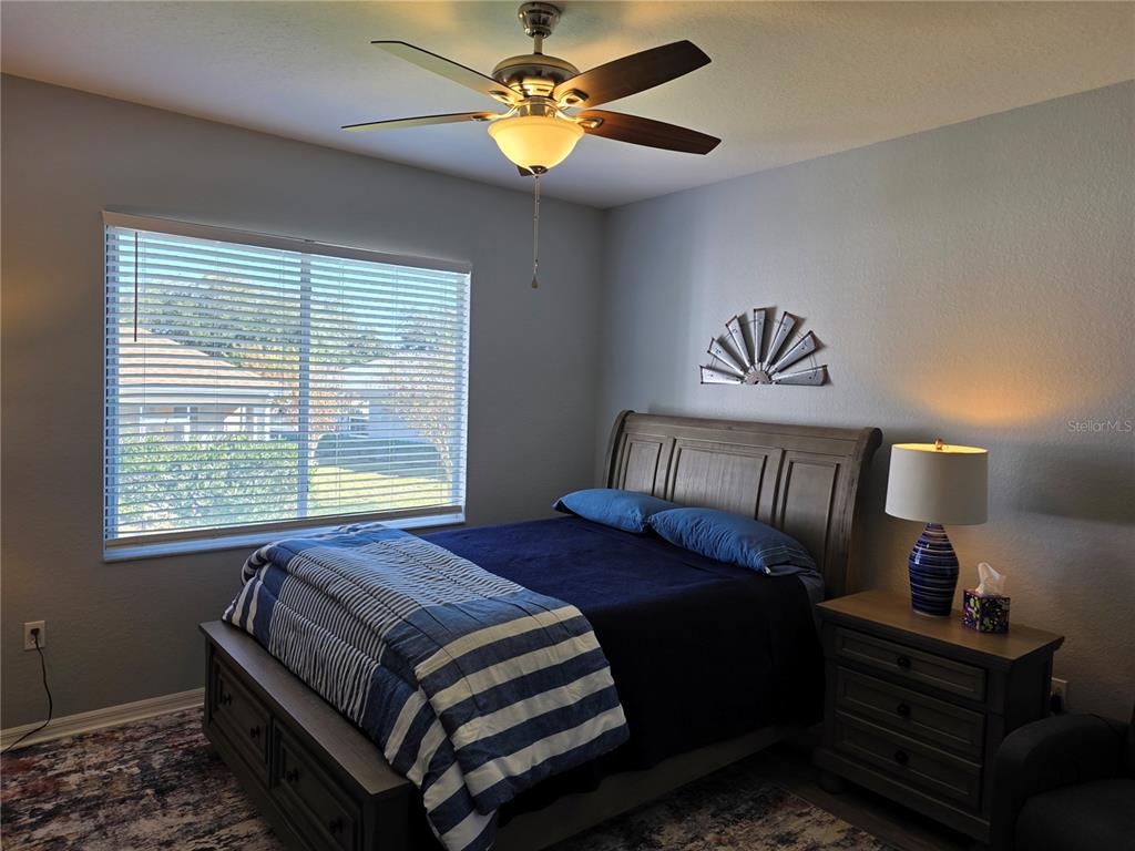 13185 Southeast 93rd Terrace Road Summerfield, FL 34491 - Photo 15 of 48 a bedroom with a bed and a chandelier