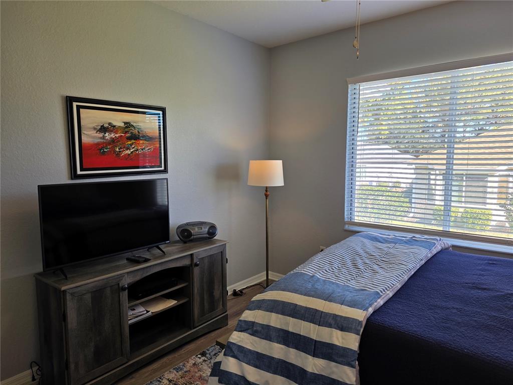 13185 Southeast 93rd Terrace Road Summerfield, FL 34491 - Photo 16 of 48 a bedroom with furniture and flat screen tv