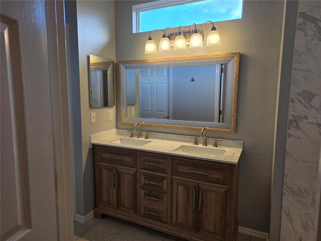13185 Southeast 93rd Terrace Road Summerfield, FL 34491 - Photo 19 of 48 a bathroom with a double vanity sink and a mirror