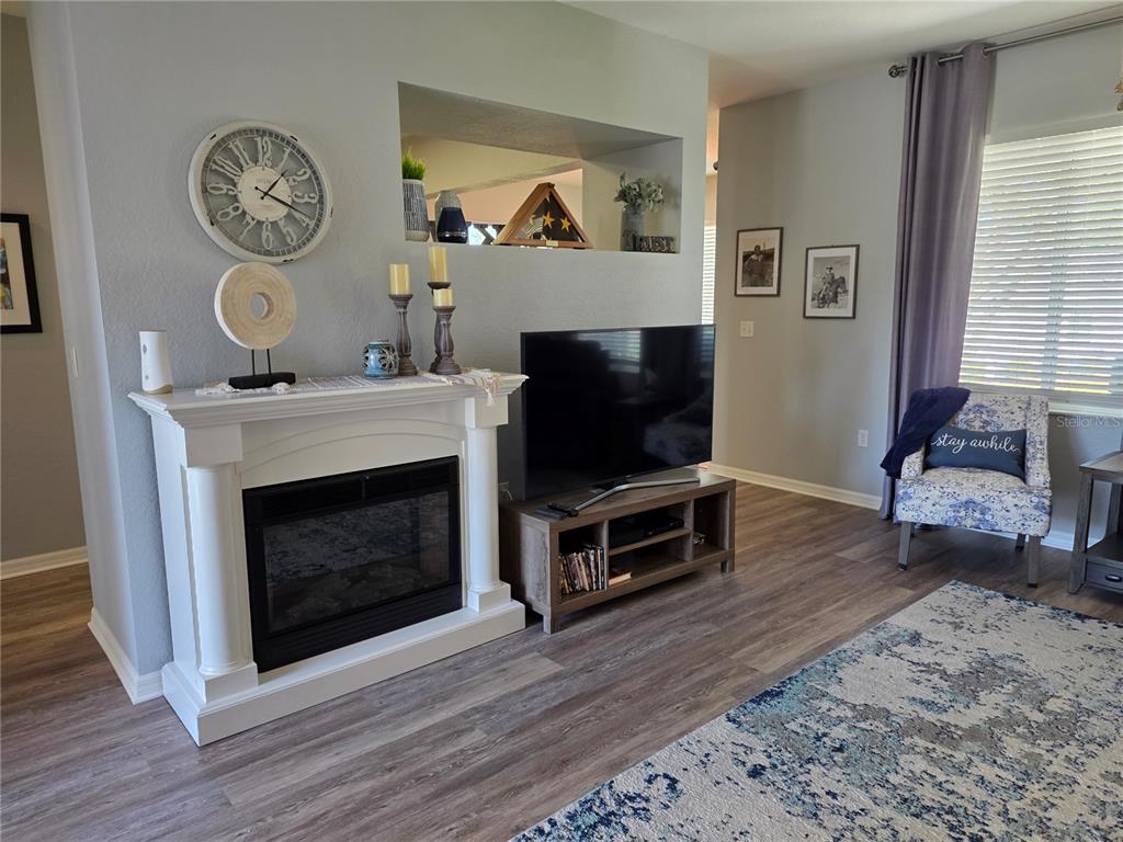 13185 Southeast 93rd Terrace Road Summerfield, FL 34491 - Photo 8 of 48 a living room with furniture a fireplace and a flat screen tv