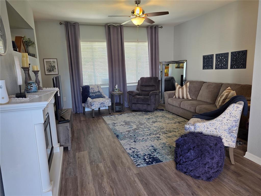 13185 Southeast 93rd Terrace Road Summerfield, FL 34491 - Photo 9 of 48 a living room with furniture and a flat screen tv
