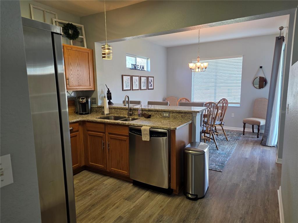 13185 Southeast 93rd Terrace Road Summerfield, FL 34491 - Photo 10 of 48 a kitchen with stainless steel appliances granite countertop a sink stove and wooden floor