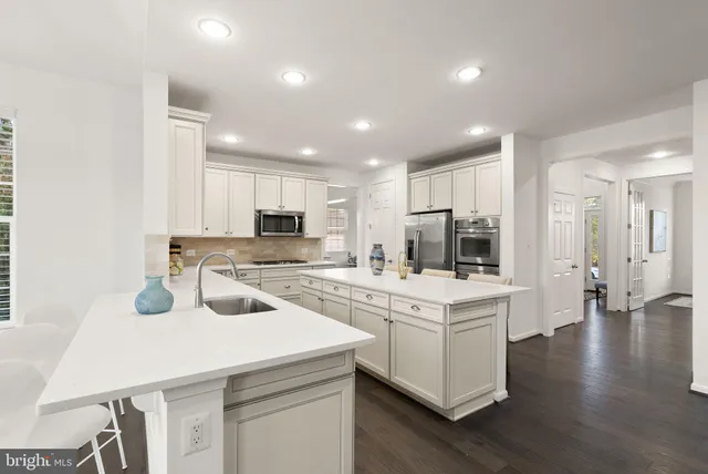 a spacious bedroom with a large bed a chandelier and windows