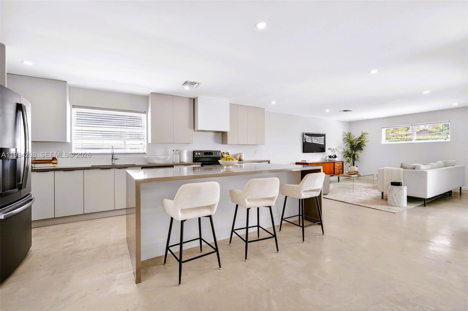 1119 North 46th Terrace Hollywood, FL 33021 - Photo 11 of 41 a kitchen with stainless steel appliances kitchen island granite countertop a table chairs sink and cabinets
