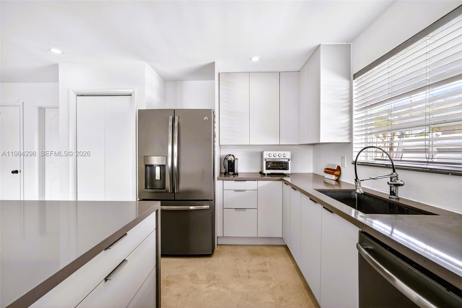 1119 North 46th Terrace Hollywood, FL 33021 - Photo 16 of 41 a kitchen with a refrigerator sink and cabinets