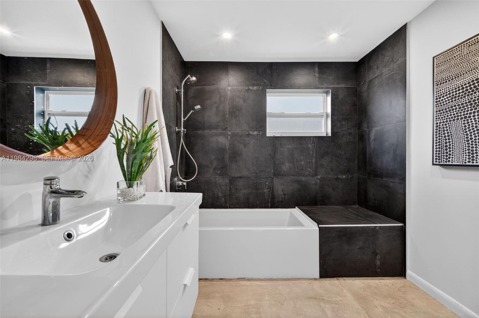 1119 North 46th Terrace Hollywood, FL 33021 - Photo 25 of 41 a bathroom with a tub a sink and mirror