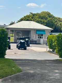 a view of a white house with a fountain and a yard
