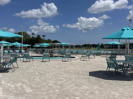 a view of a swimming pool with table and chairs