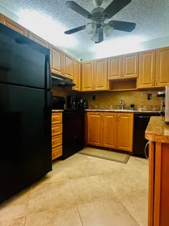 a kitchen with stainless steel appliances granite countertop a refrigerator and a sink