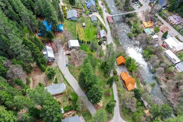 an aerial view of a house with a yard and greenery