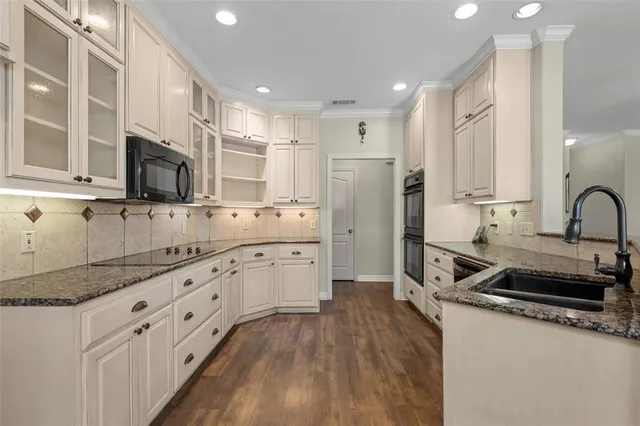 a kitchen with granite countertop a refrigerator stove top oven and sink