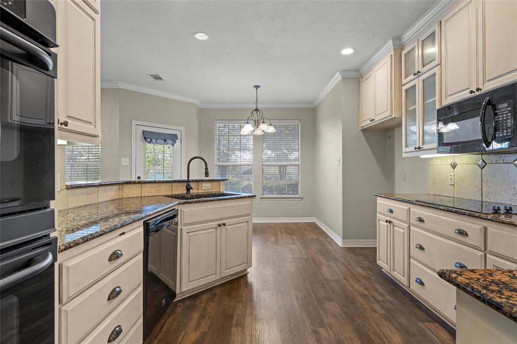 5624 Rosalie Drive Waco, TX 76708 - Photo 15 of 39 a kitchen with stainless steel appliances granite countertop a sink dishwasher a stove and white cabinets with wooden floor