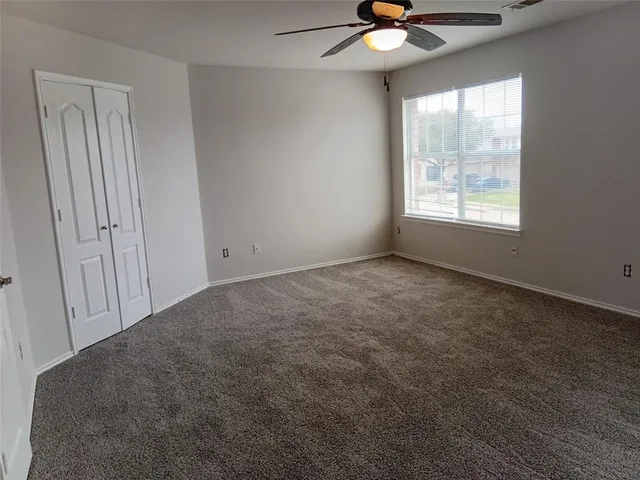a view of a room with a window and a ceiling fan