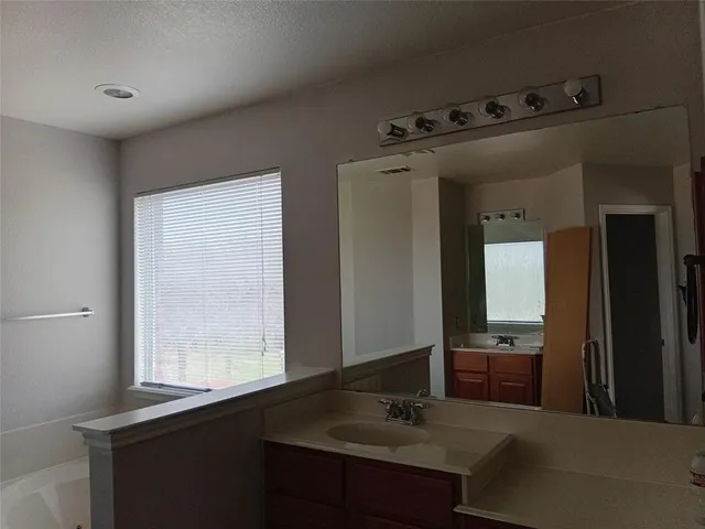 a bathroom with a sink vanity and mirror