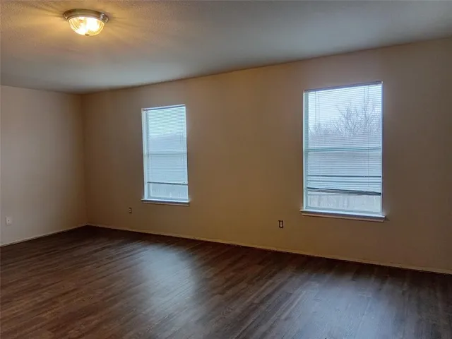 a view of an empty room window and wooden floor