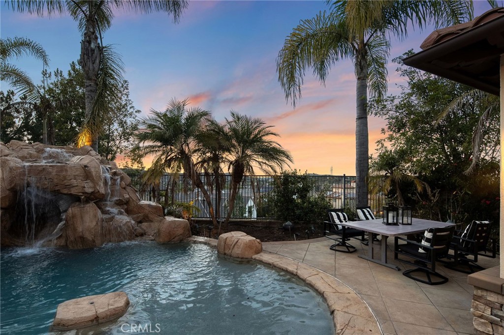33 Basilica Place Ladera Ranch, CA 92694 - Photo 49 of 59 a row of palm trees and swimming pool in the backyard of a house