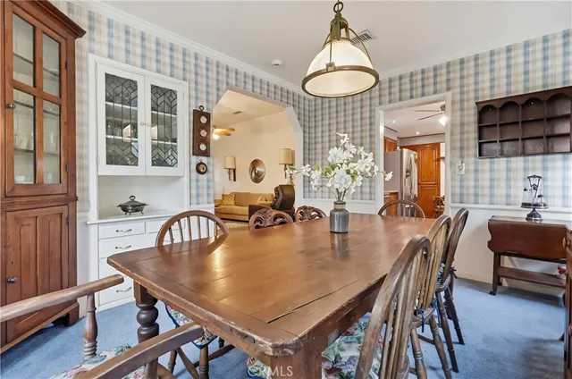 a dining room with wooden floor a chandelier a wooden table and chairs