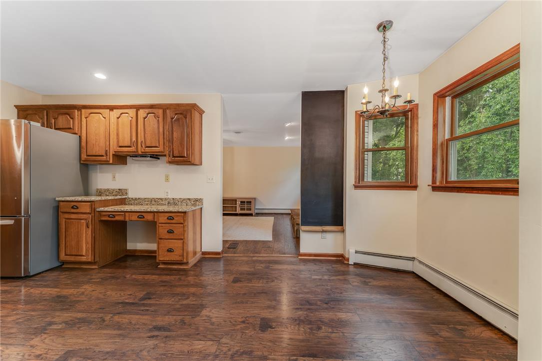465 Raubsville Road Easton, PA 18042 - Photo 20 of 60 An inviting eat-in kitchen with warm wooden cabinetry flows into an adjacent living space, perfect for entertaining.