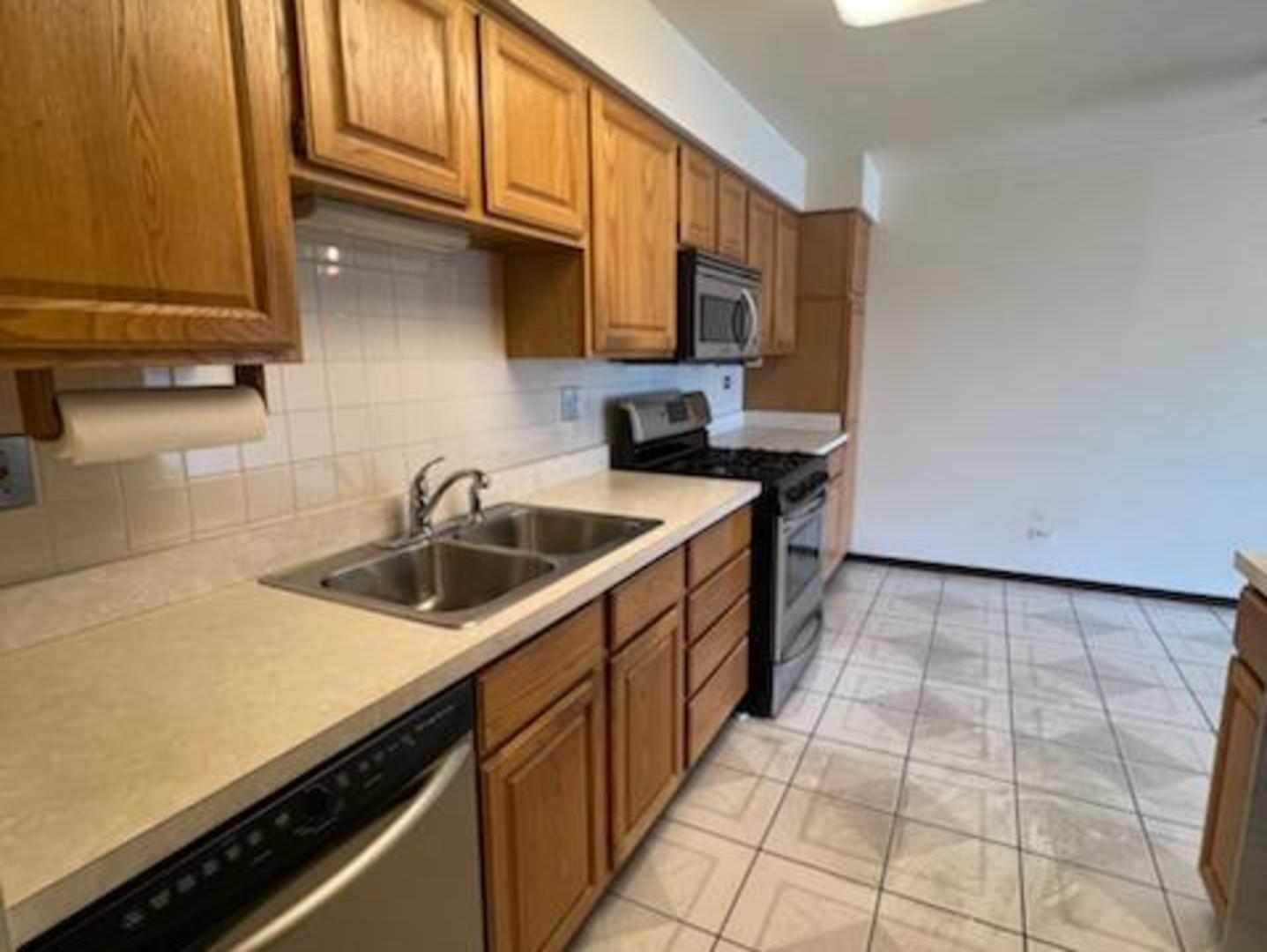 239 North Mill Road, Unit 405A Addison, IL 60101 - Photo 4 of 14 a kitchen with a sink and cabinets