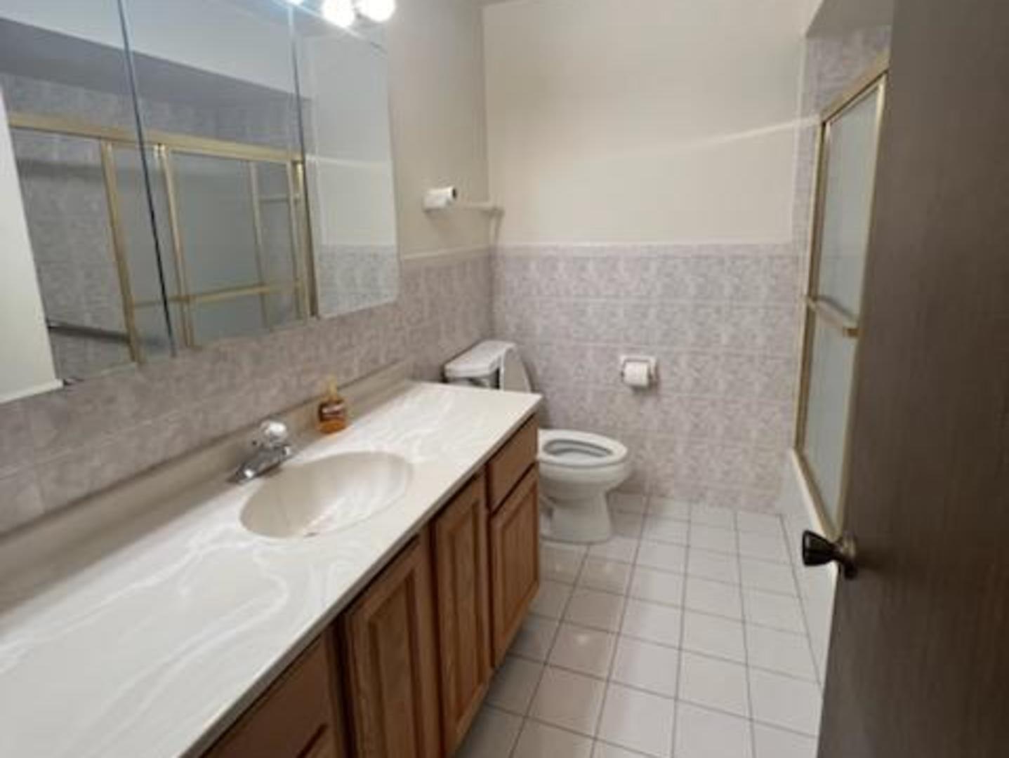 239 North Mill Road, Unit 405A Addison, IL 60101 - Photo 5 of 14 a bathroom with a sink toilet and shower
