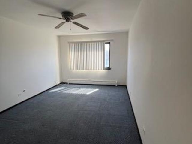239 North Mill Road, Unit 405A Addison, IL 60101 - Photo 7 of 14 an empty room with ceiling fan and windows