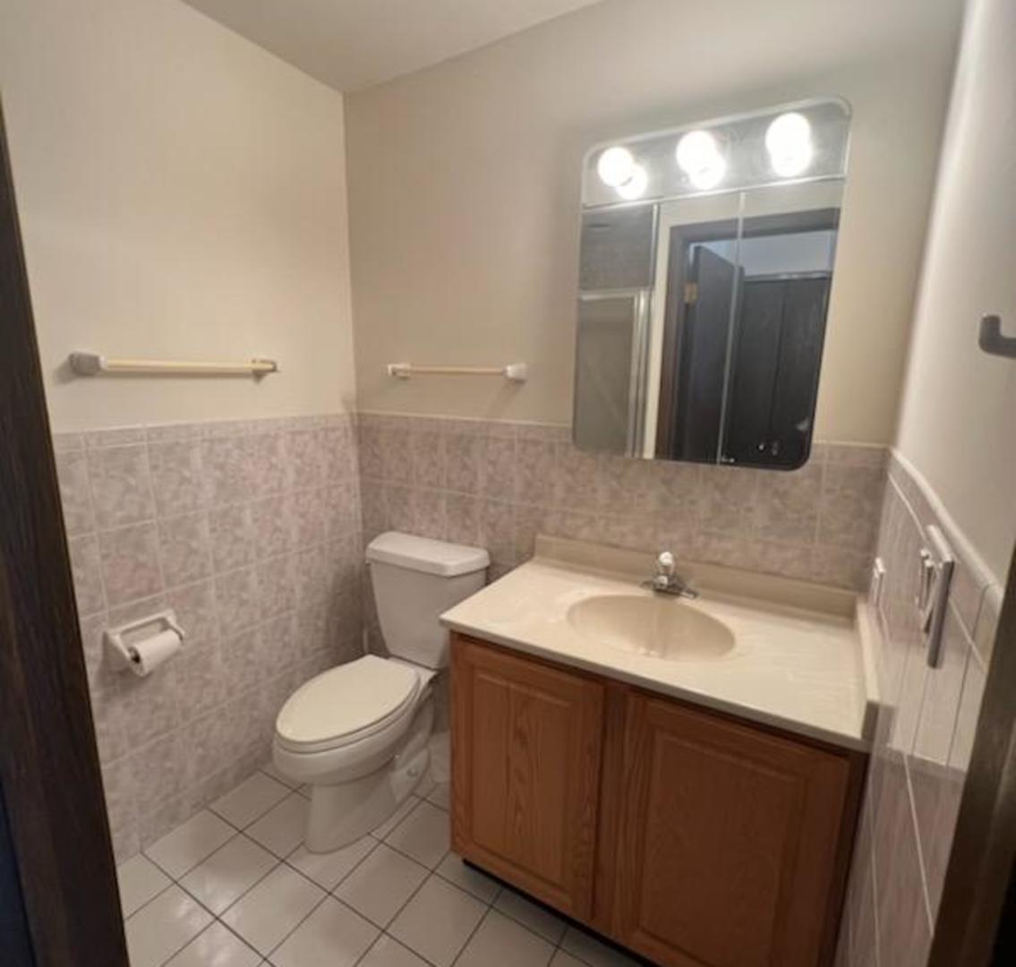 239 North Mill Road, Unit 405A Addison, IL 60101 - Photo 10 of 14 a bathroom with a sink toilet and mirror